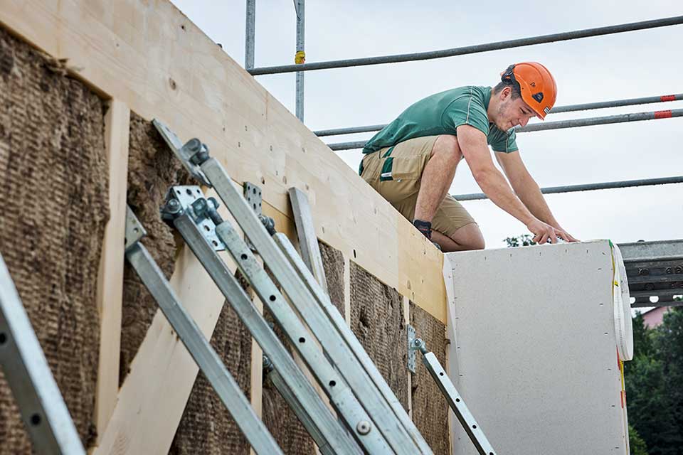 Ein Haupt Mitarbeiter setzt ein Holzbauelement ein